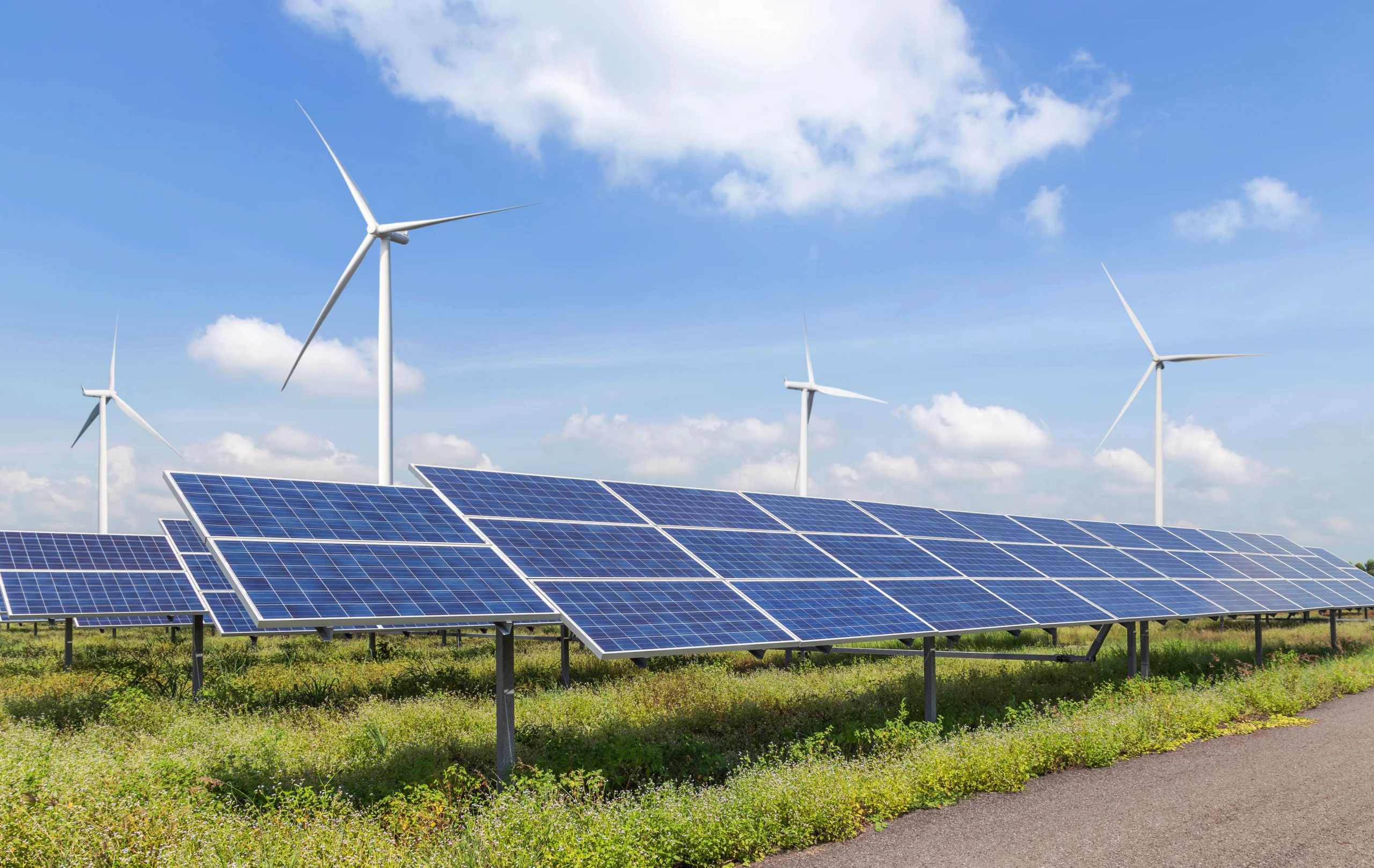 Solarpark mit Photovoltaikmodulen und Windrädern.