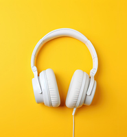 Weiße Over-Ear-Kopfhörer mit Kabel, fotografiert von oben vor einem leuchtend gelben Hintergrund.