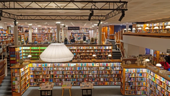 Bücherladen mit zwei Etagen und großer Deckenlampe.