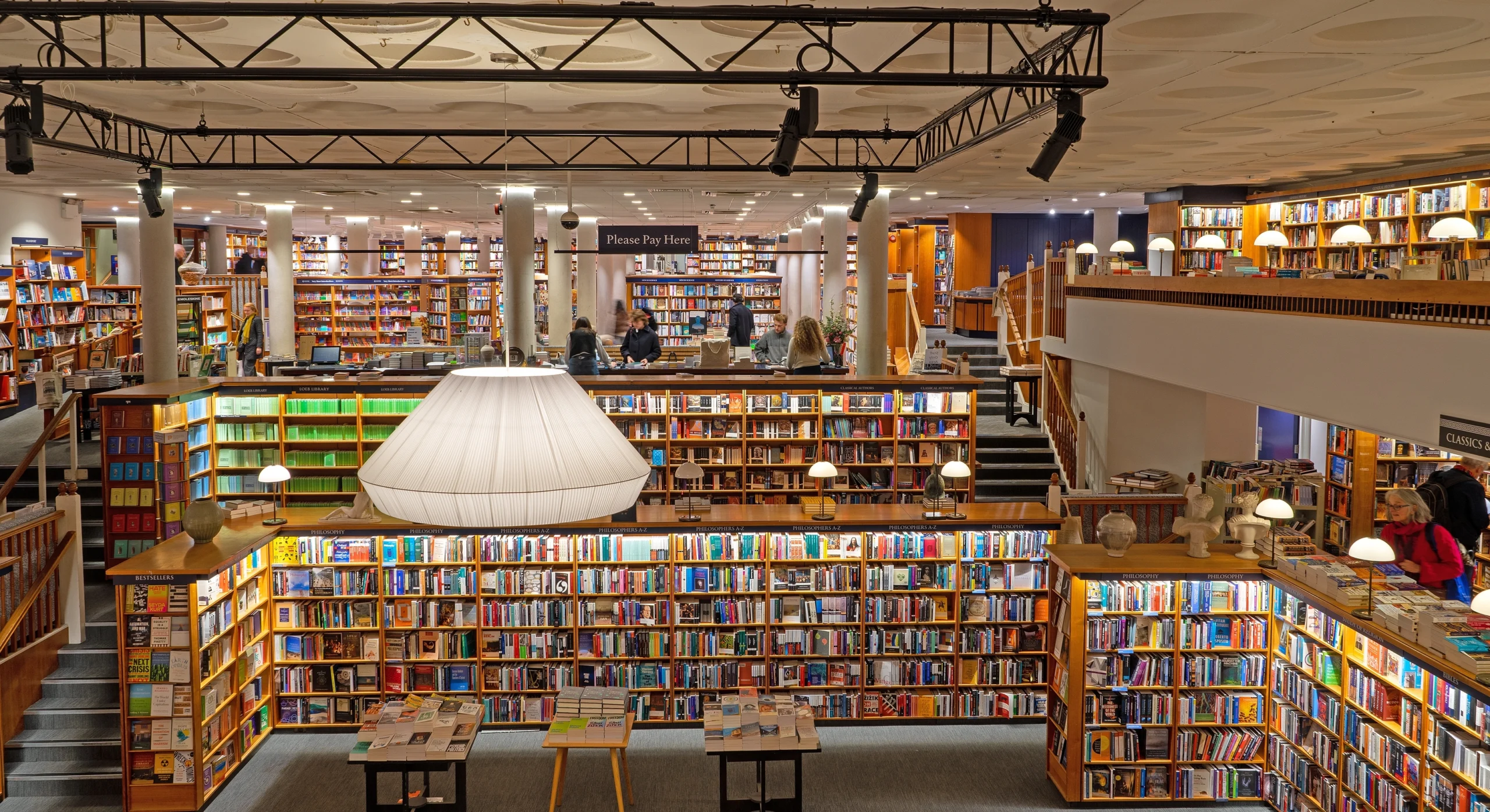 Bücherladen mit zwei Etagen und großer Deckenlampe.