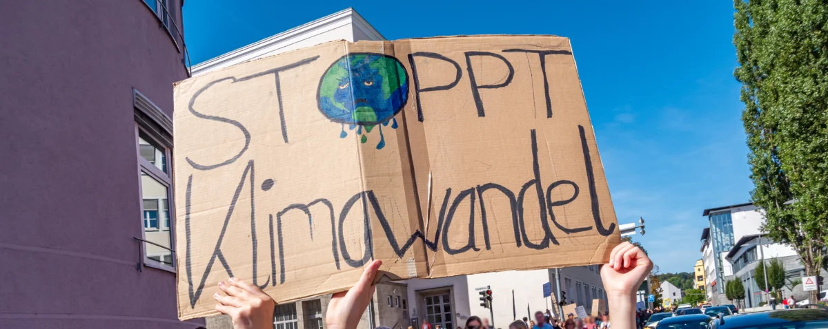 Schild mit trauriger Weltkugel mit Text stoppt Klimawandel