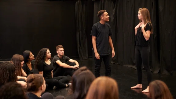 Jugendliche führen einen Theaterworkshop im Studio auf.